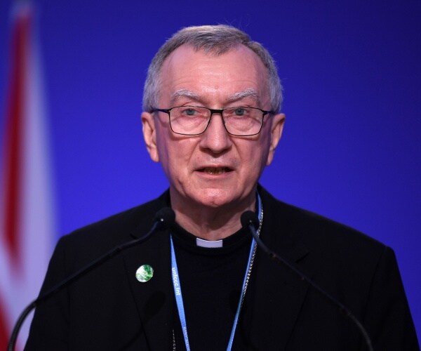 pietro parolin speaks into a microphone