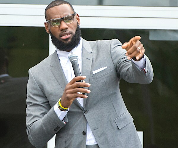 lebron james leans back slightly, pointing forward with both hands, with the right just behind the left like a bowhunter