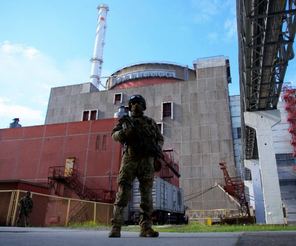a russian serviceman stands guard at the zaporizhzhia nuclear power station