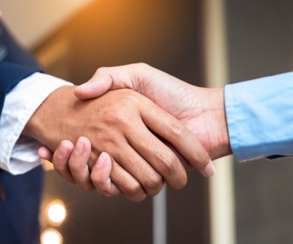 Close up businessmen shaking hands during a meeting