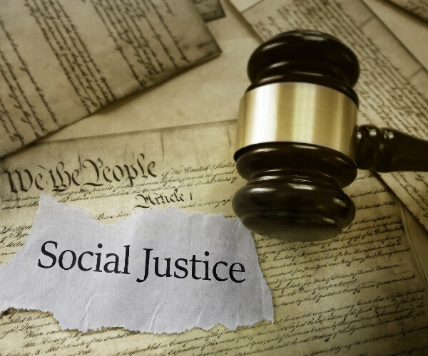 the constitution a judges gavel and piece of paper reading social justice