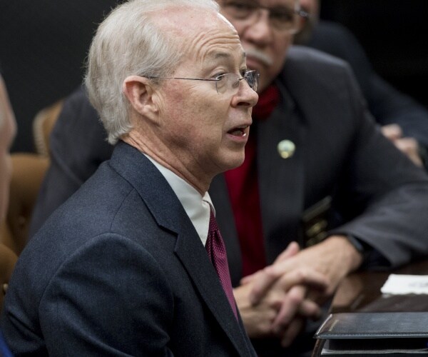 boente in a suit and burgundy tie speaking
