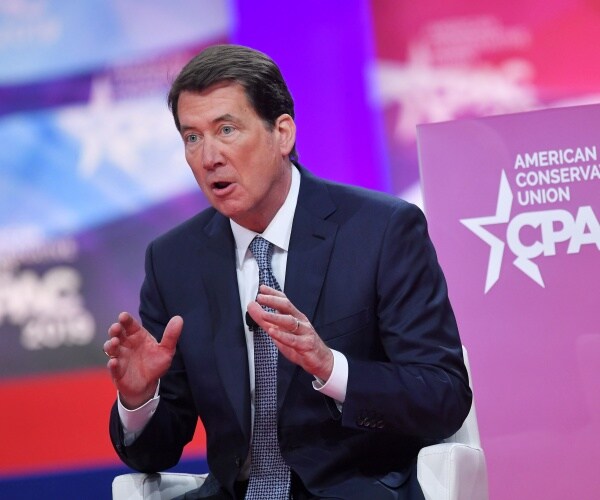 hagerty in a suit and gray tie speaking at cpac