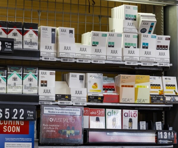 cigarettes, e-cigarettes and other products on shelves in store