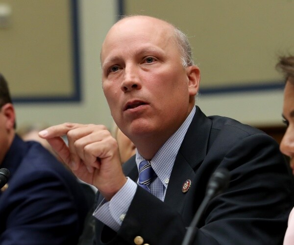 chip roy in a suit and blue shirt and tie