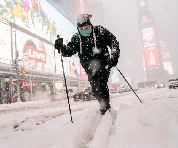 a skier pumps his arms through times square in new york city