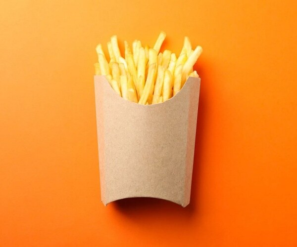 french fries in cardboard holder with orange background