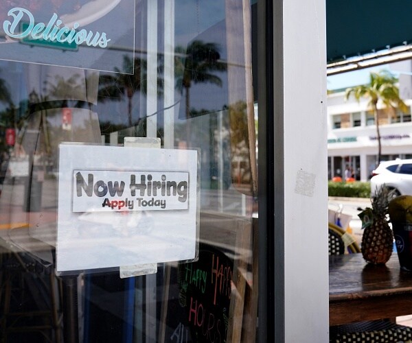 now hiring sign hangs on door