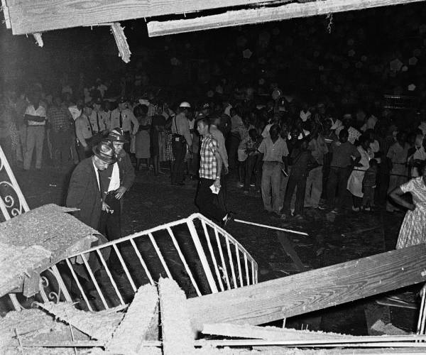 firefighters and neighbors observe the rubble