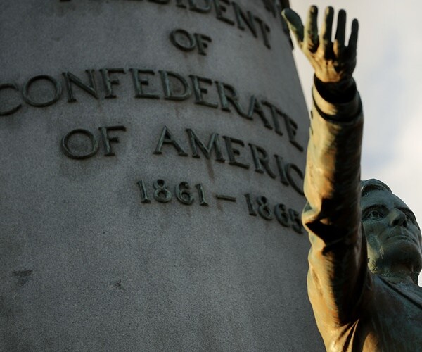 a jefferson davis statue holds its hand up