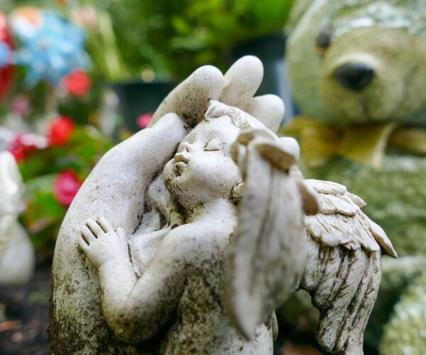 baby angel stone marker in cemetery 