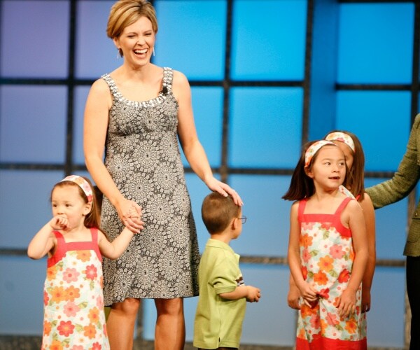 kate gosselin in a gray dress with four of her kids with the girls wearing matching flower print dresses