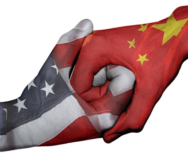diplomatic handshake between countries: flags of united states and china overprinted the two hands 

