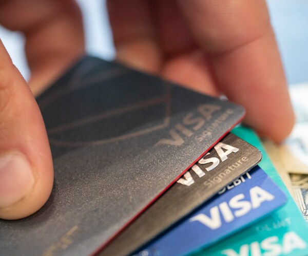 a hand holding a stack of visa credit cards