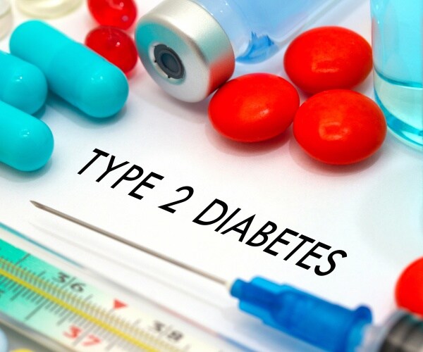 'Diabetes treatment' written on pad with drugs and syringes around it