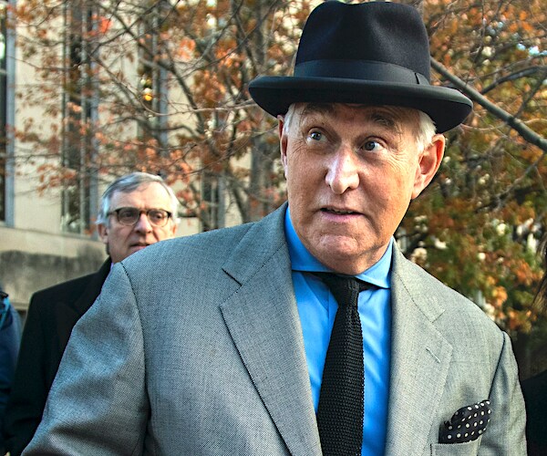 roger stone, wearing a black top hat, walks out of federal court as his defense rests