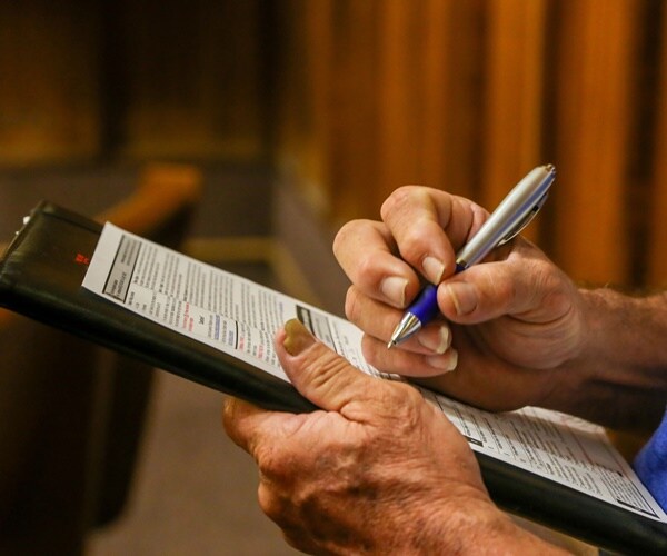 a man signs a voter registration form