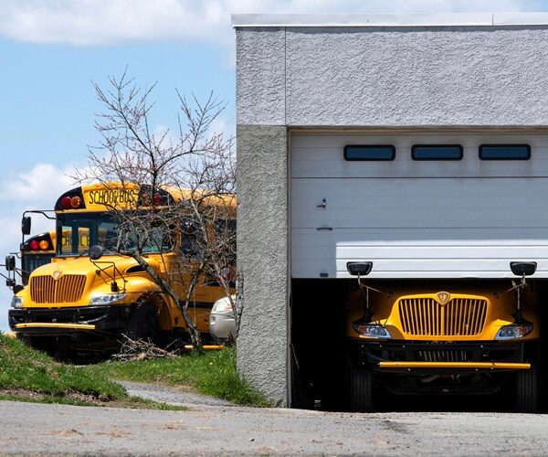 school busses are parked at and in the garage