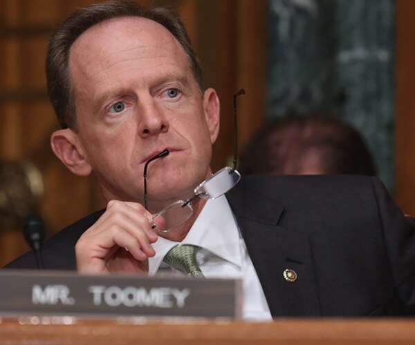 sen. pat toomey listens to a speaker at a senate hearing
