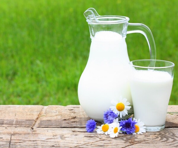 pitcher of milk is shown on a wooden table