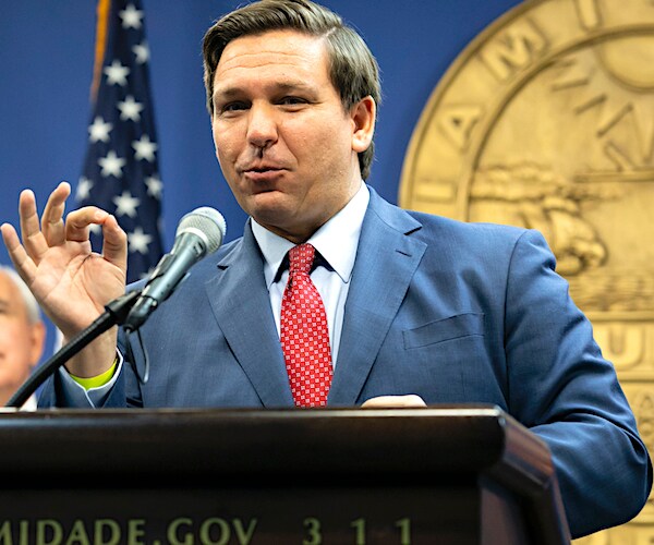 ron desantis gives the okay sign while speaking to the media