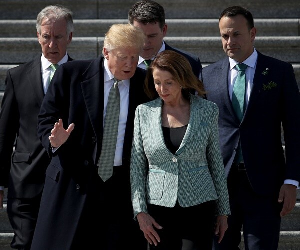 the president and nancy pelosi speaks as they walk down the steps of the captiol