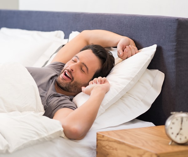 a man stretching in bed