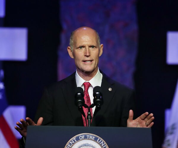florida republican senator rick scott speaks from behind a podium