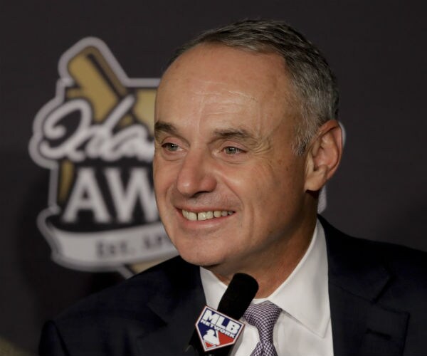 mlb commissiner robert manfred jr smiles during a baseball game