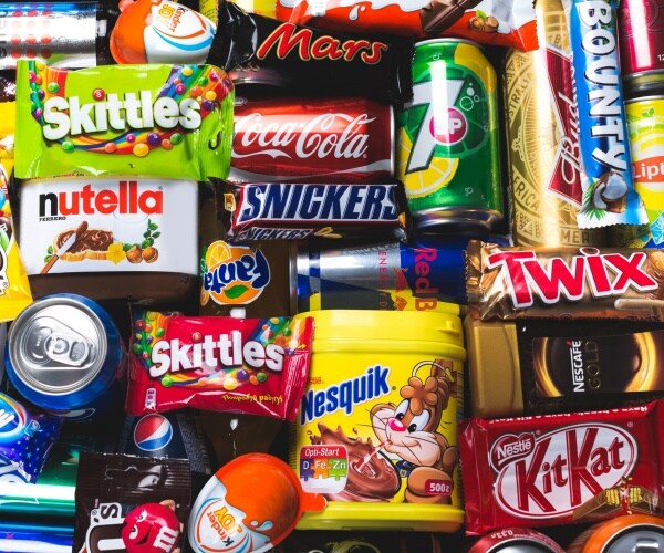 unhealthy food in colorful packaging soda, candy, energy drinks, chocolate etc.