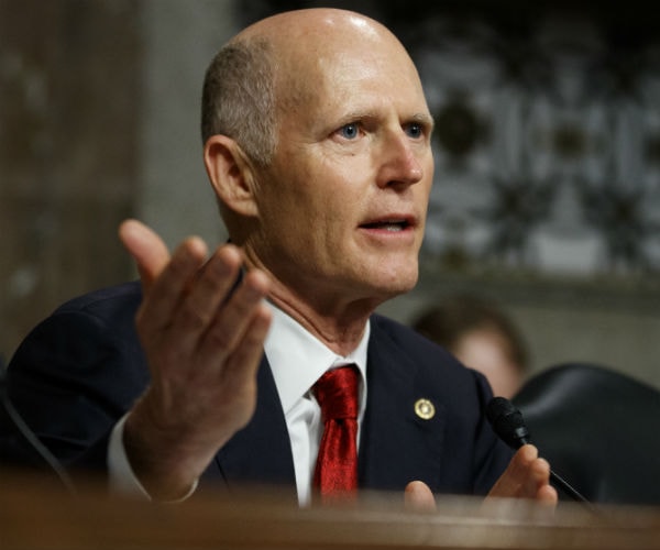 sen. rick scott is shown on capitol hill in blue suit, white dress shirt and red tie