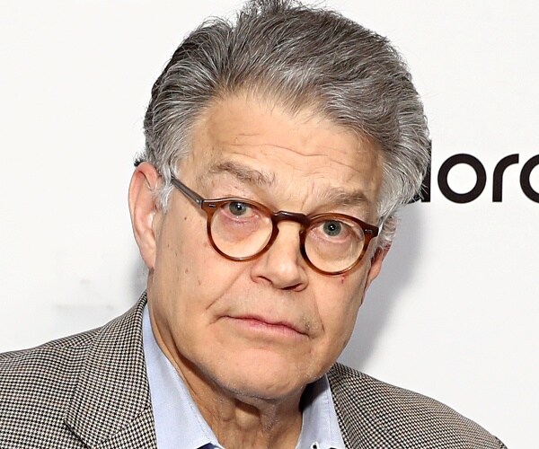 al franken stands in front of photo backdrop