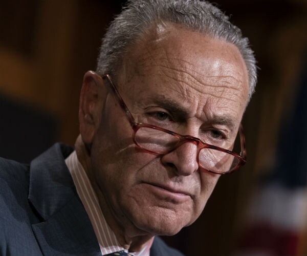 Senate Minority Leader Chuck Schumer is shown with his signature red glasses tipping off his nose.