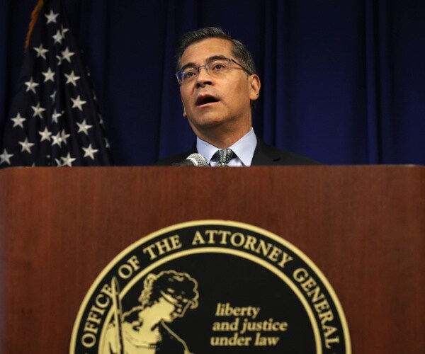 becerra speaking at a wooden podium