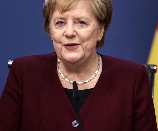 angela merkel speaks into microphone