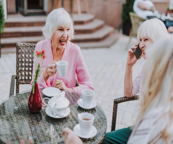 older women laughing at an outdoor cafe
