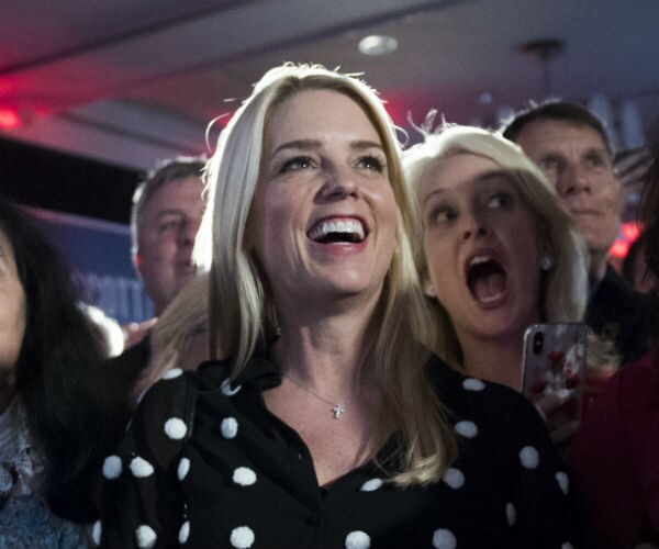 pam bondi is shown in a black and white polka dot blouse