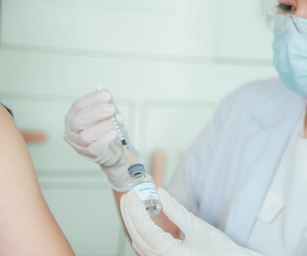 healthcare worker giving monkeypox vaccine to a person