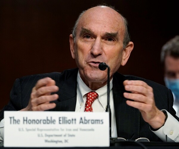 elliott abrams gestures from behind desk