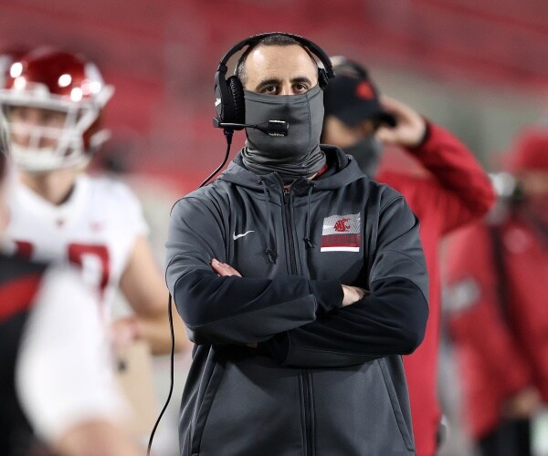 Washington State University’s football coach Nick Rolovich stands on the field
