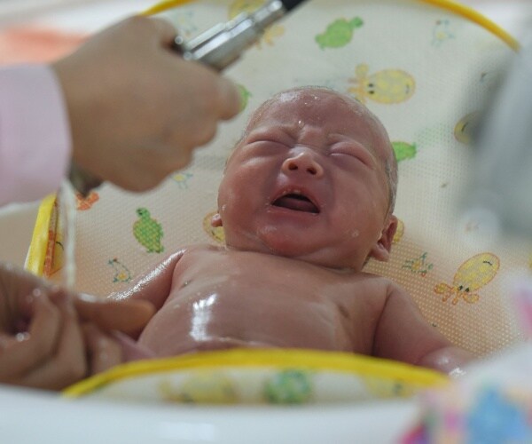 a new born baby is having his stats taken