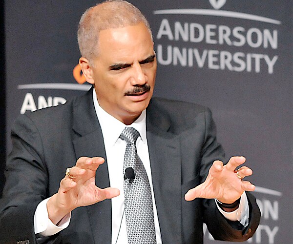 eric holder grabs at the air as he speaks to the media