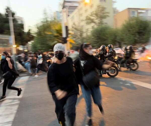 women run away from anti-riot police
