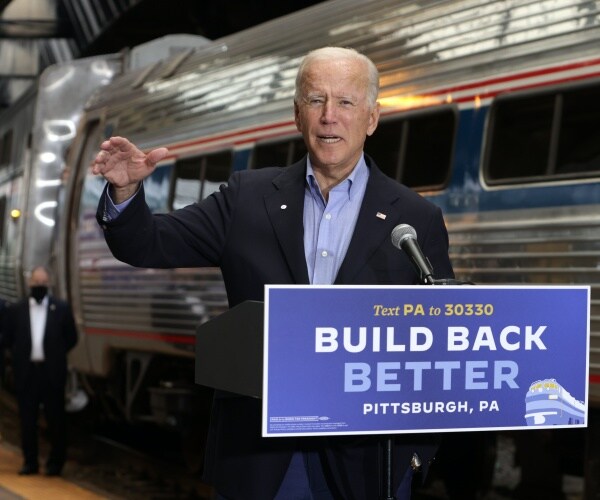 joe biden standing in front of a train