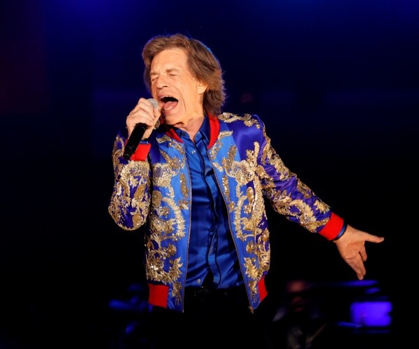 mick jagger sings into a microphone