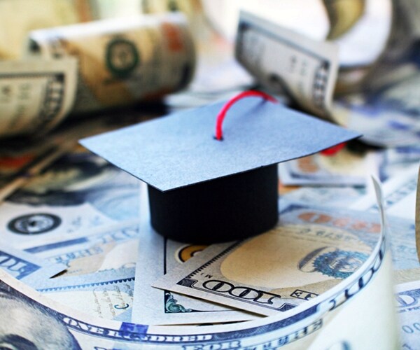 student loan debt with graduation cap on money