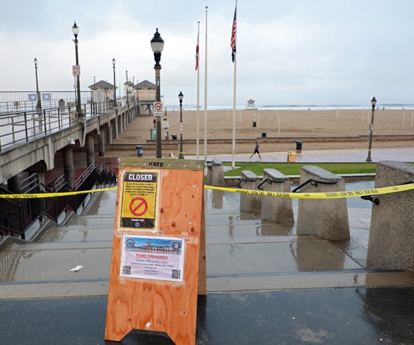 a sign indicating the huntington beach pier in california is closed