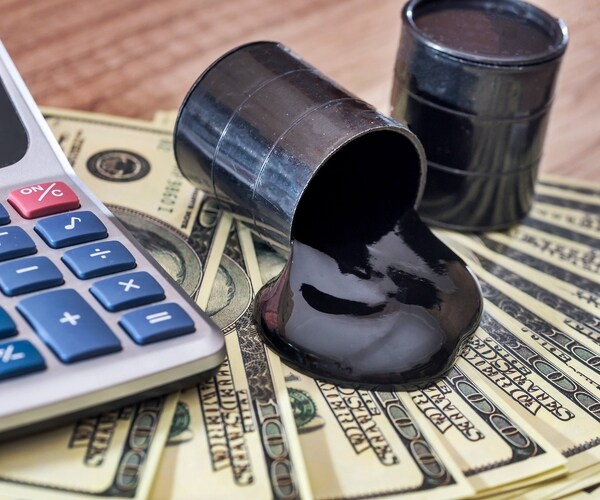 barrels of oil with dollar money on wooden desk. business concept 

