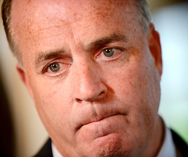 dan kildee looks down solemnly during an interview