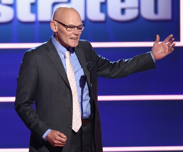 carville in a suit and light blue shirt speaking on a stage